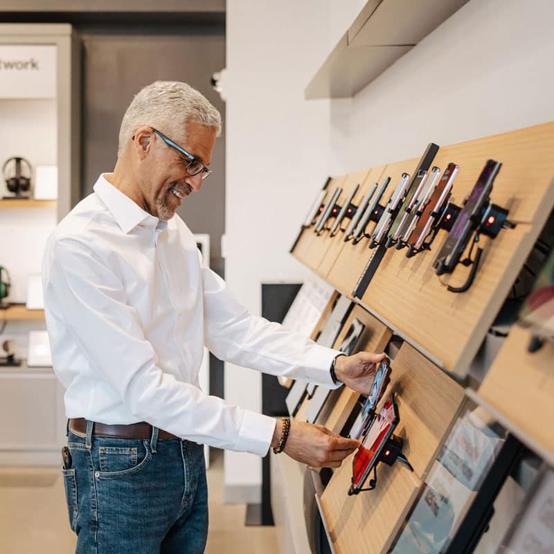 Man browsing the phone section in the Verizon store